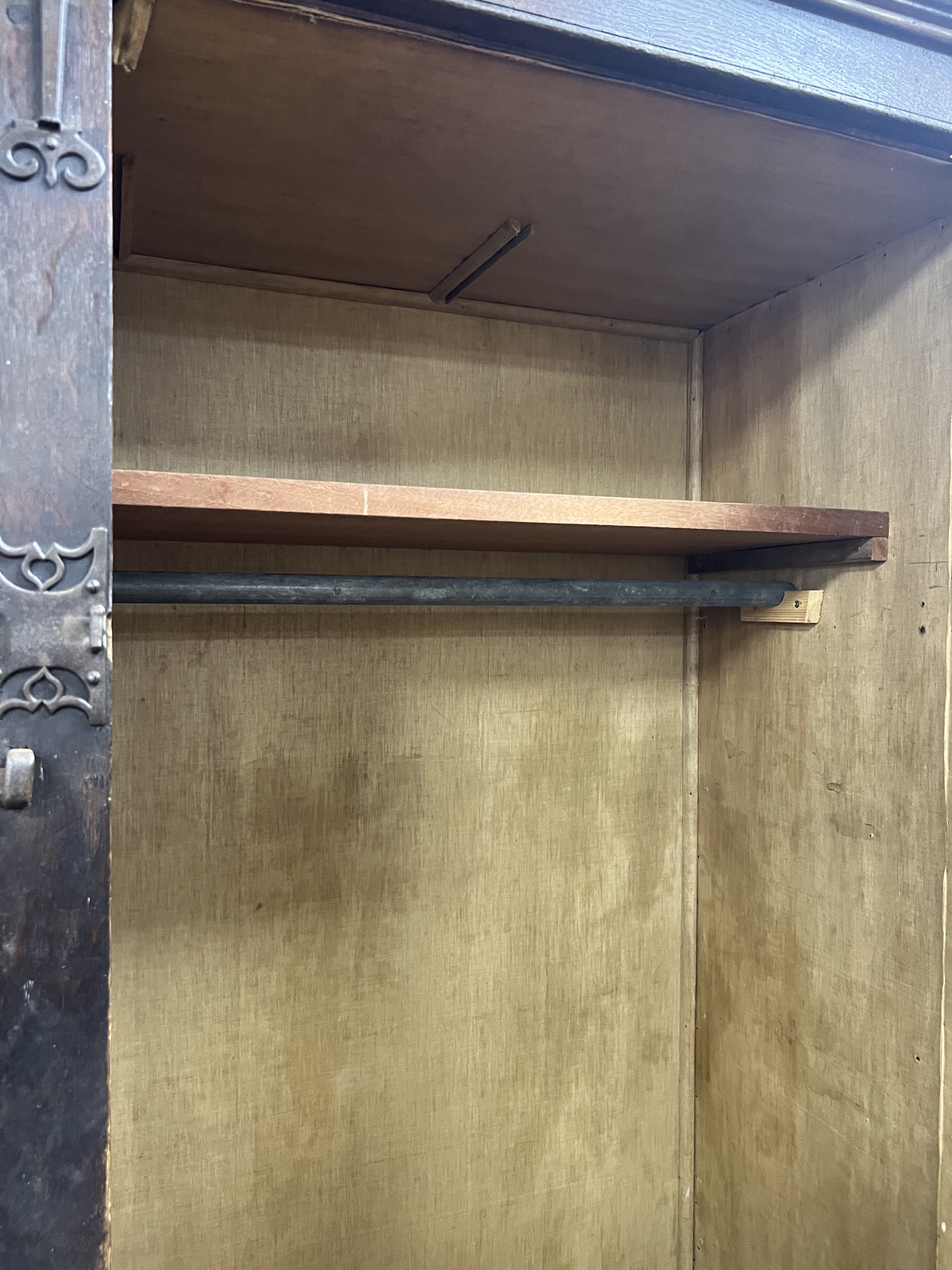 A pair of 16th century German or Netherlandish oak and wrought iron strapwork window shutters, later mounted on a cupboard, the moulded cornice above two pairs of hinged shutters, (previously bi-fold), mounted with elabo
